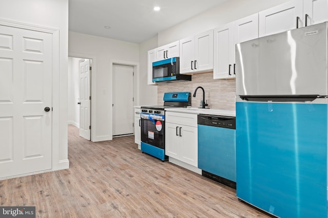 kitchen featuring a sink, tasteful backsplash, light wood-type flooring, and stainless steel appliances