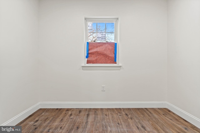 empty room featuring baseboards and wood finished floors