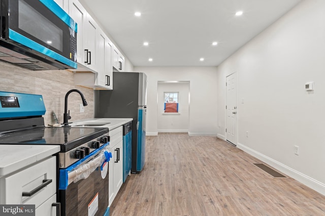 kitchen featuring white cabinetry, light countertops, electric stove, and visible vents