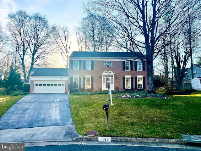 colonial home featuring a garage, brick siding, concrete driveway, and a front yard