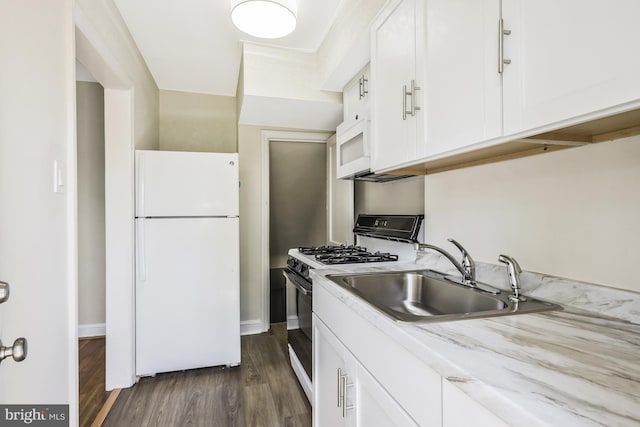 kitchen with freestanding refrigerator, a sink, dark wood-type flooring, white cabinets, and gas range oven