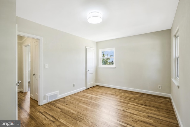 unfurnished bedroom with visible vents, baseboards, a closet, and wood finished floors