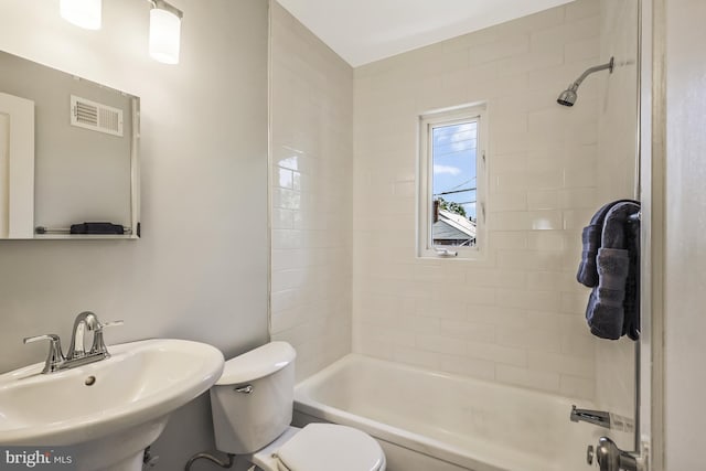 bathroom featuring a sink, visible vents, toilet, and shower / tub combination