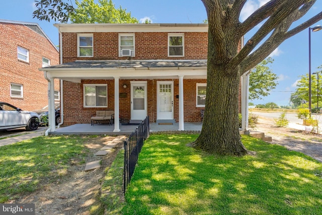 view of front of home with a porch, brick siding, and a front lawn