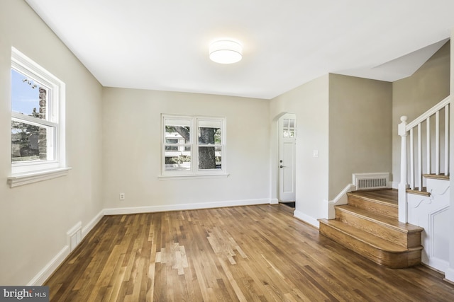 entryway featuring visible vents, stairway, baseboards, and wood finished floors