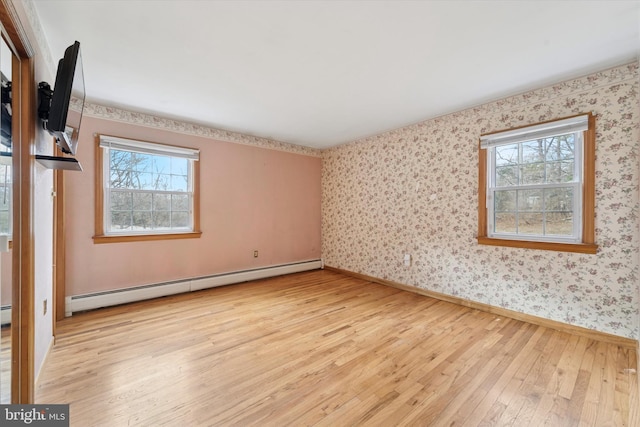 interior space with wallpapered walls, light wood-style flooring, baseboards, and a baseboard radiator