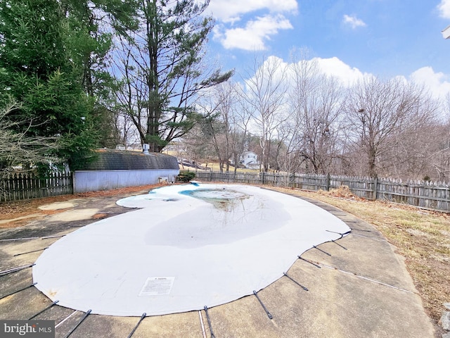 view of pool with an outdoor structure, a fenced backyard, and a fenced in pool