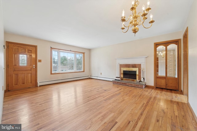 unfurnished living room featuring a chandelier, baseboard heating, a brick fireplace, and light wood-style flooring