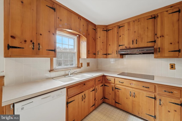 kitchen featuring light floors, a sink, under cabinet range hood, dishwasher, and black electric cooktop