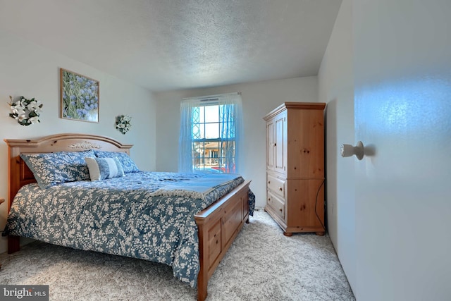 bedroom with light carpet and a textured ceiling