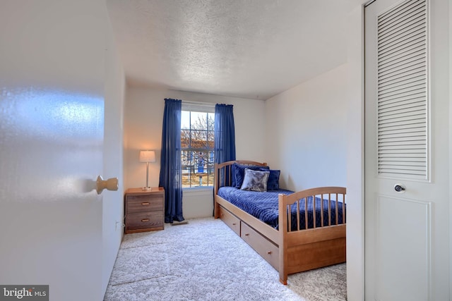 bedroom with carpet and a textured ceiling