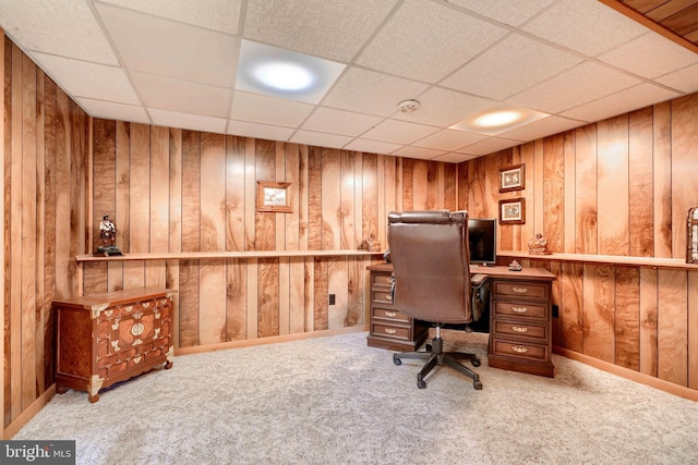 office area featuring wooden walls, carpet, baseboards, and a drop ceiling