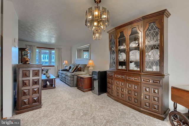 sitting room featuring a notable chandelier, carpet flooring, and a textured ceiling