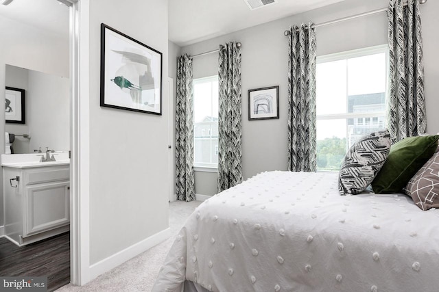 bedroom with visible vents, baseboards, carpet floors, and ensuite bathroom