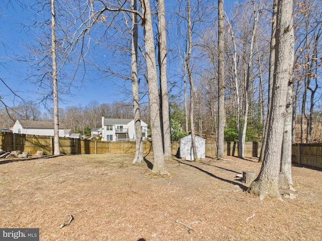 view of yard featuring an outbuilding, a storage shed, and a fenced backyard