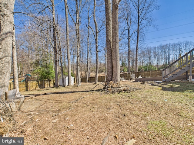 view of yard with stairway, an outbuilding, and a fenced backyard