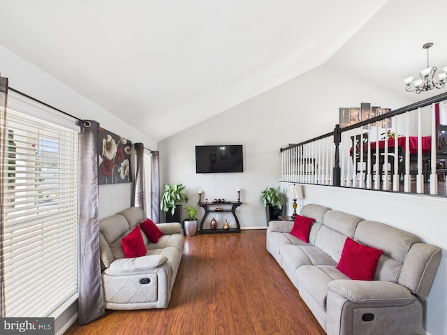 living area with a chandelier, wood finished floors, and vaulted ceiling