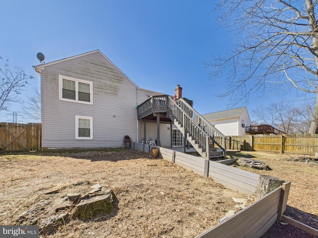 back of house with stairway, a fenced backyard, and a wooden deck