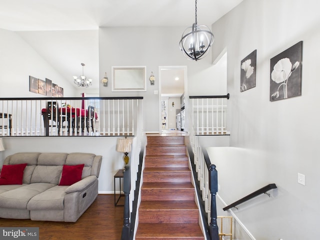 stairway with baseboards, wood finished floors, and a chandelier