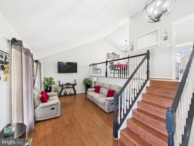 living area featuring baseboards, stairs, vaulted ceiling, wood finished floors, and a notable chandelier