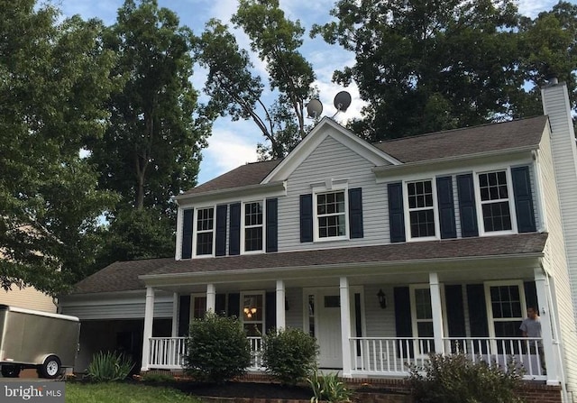 view of front of property featuring an attached garage, a porch, and a chimney