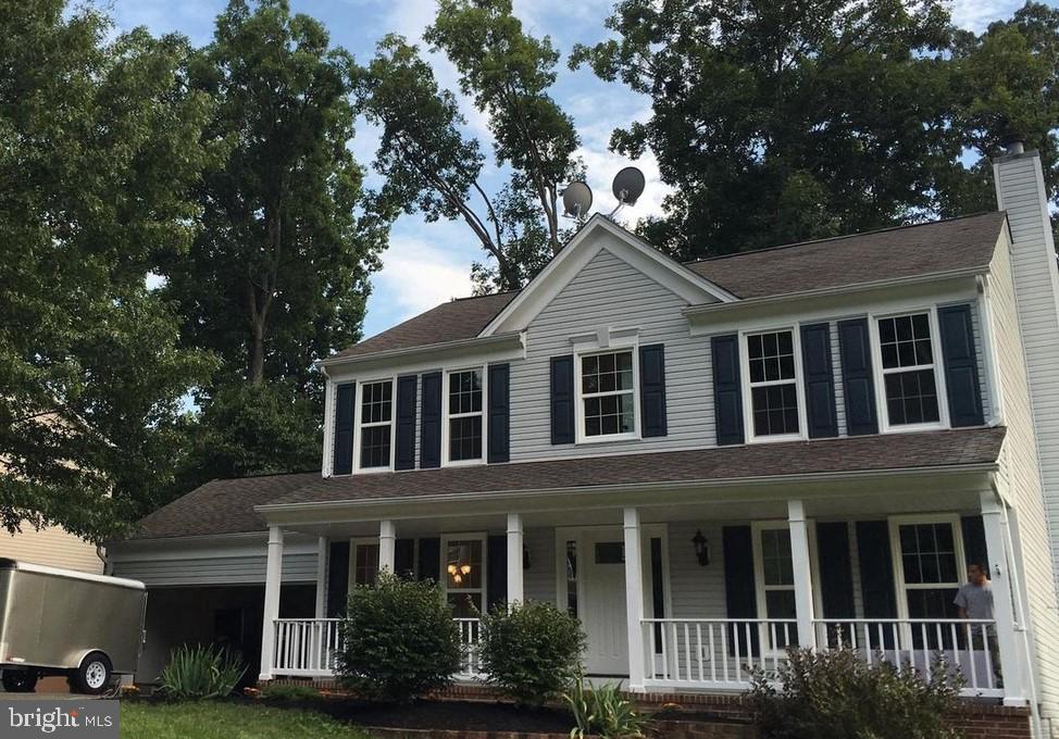 view of front of house with a porch, an attached garage, and a chimney