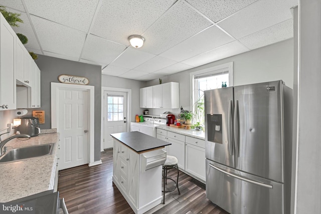 kitchen featuring a sink, a healthy amount of sunlight, white cabinets, and stainless steel fridge with ice dispenser