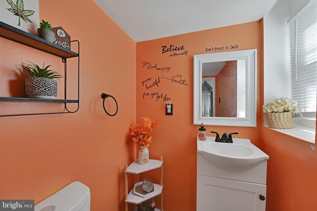 bathroom featuring plenty of natural light, toilet, and vanity