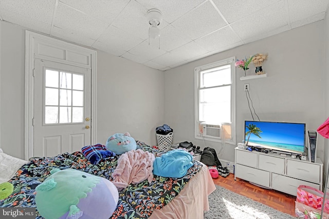 bedroom featuring cooling unit, a paneled ceiling, and ceiling fan