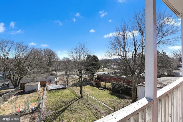 view of yard with a storage shed, an outbuilding, and fence private yard