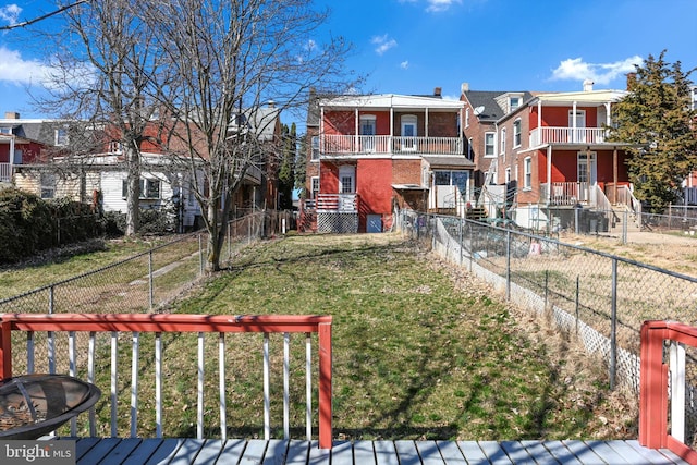 view of front of home featuring a front lawn, brick siding, a residential view, and a fenced backyard