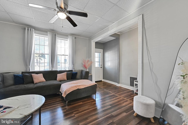 living room with a healthy amount of sunlight, a paneled ceiling, and dark wood-style flooring