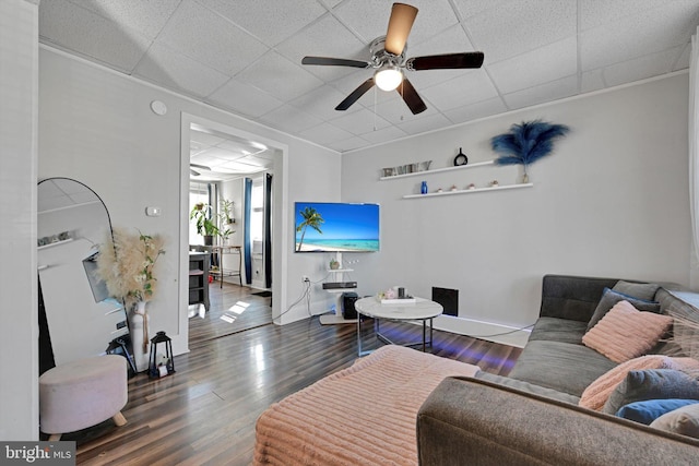 living area featuring a drop ceiling, baseboards, a ceiling fan, and wood finished floors