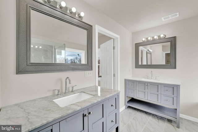 full bath featuring marble finish floor, a sink, two vanities, and visible vents