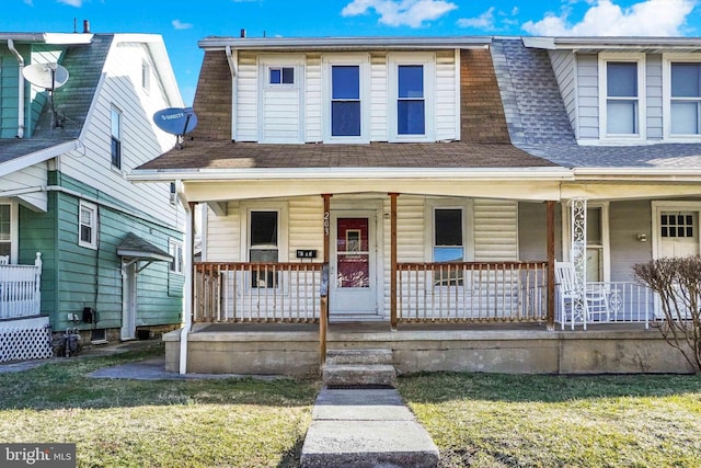 view of front of home with a front yard, covered porch, and roof with shingles