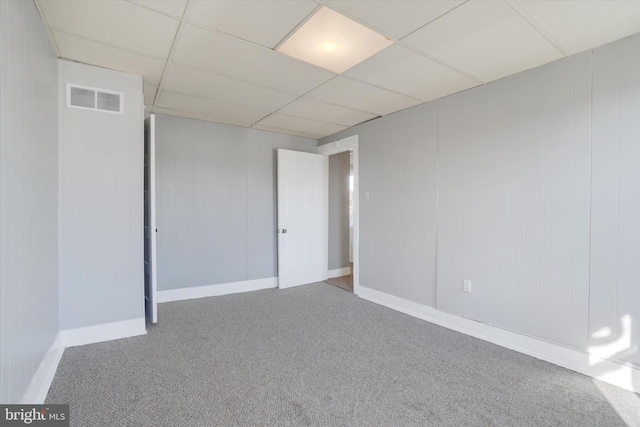 basement featuring visible vents, carpet flooring, baseboards, and a drop ceiling