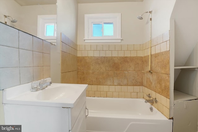 bathroom with vanity, tile walls, and  shower combination