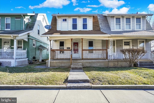 view of front of home featuring covered porch, a shingled roof, and a front lawn