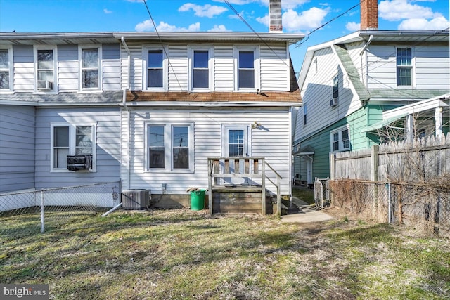 rear view of property with cooling unit, fence, and central AC