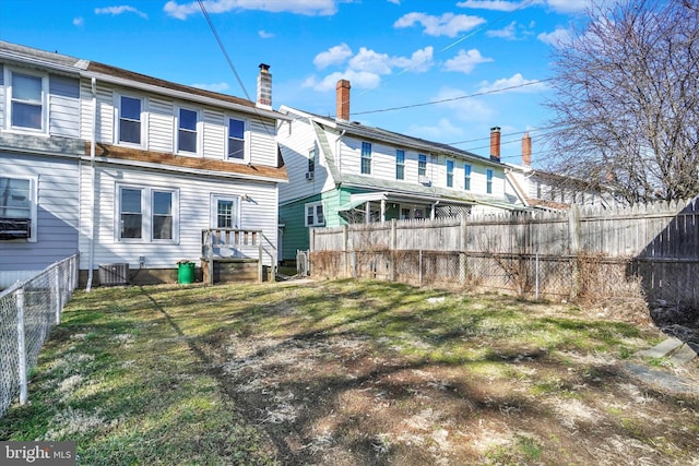 back of house with a chimney and fence