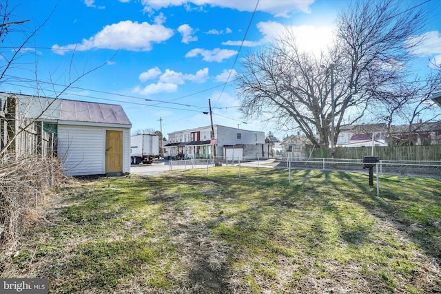 view of yard with a storage shed, an outdoor structure, and fence