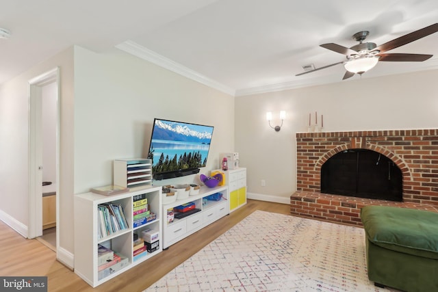living area featuring wood finished floors, visible vents, a ceiling fan, ornamental molding, and baseboards