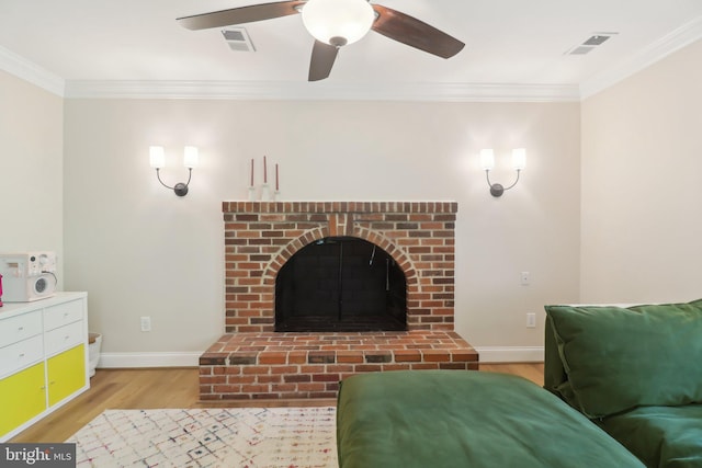 living room featuring visible vents, a ceiling fan, light wood-type flooring, crown molding, and baseboards