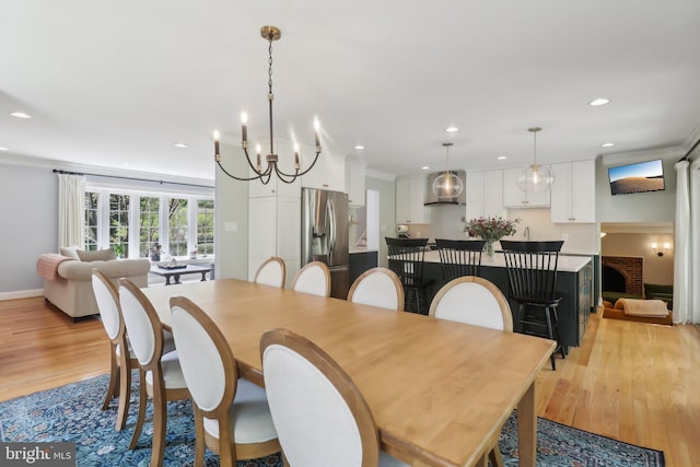 dining room featuring recessed lighting, light wood-style floors, a chandelier, and ornamental molding
