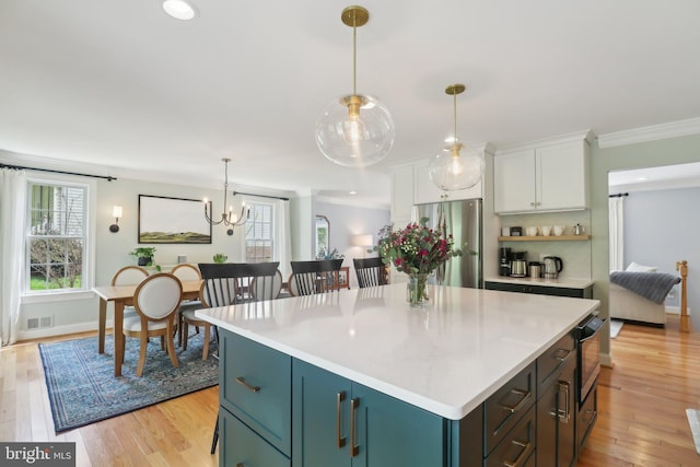 kitchen featuring light countertops, visible vents, freestanding refrigerator, light wood-type flooring, and white cabinetry