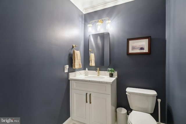 bathroom with toilet, crown molding, and vanity