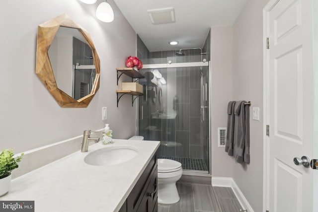 bathroom featuring visible vents, toilet, vanity, baseboards, and a stall shower