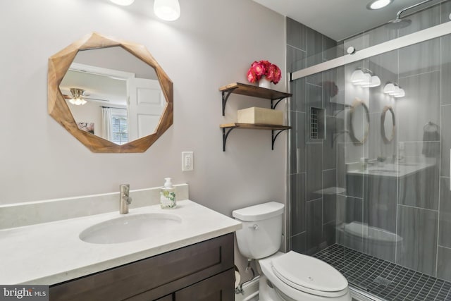 bathroom with a shower stall, toilet, and vanity