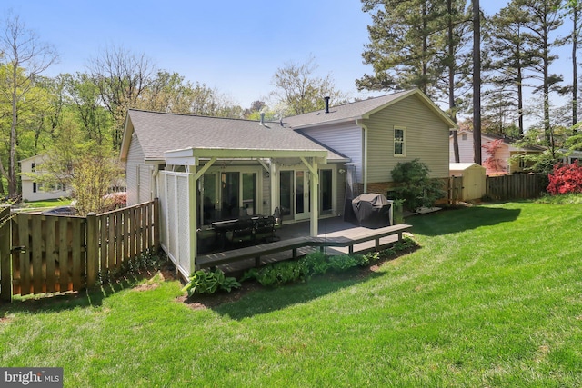 back of house with a lawn, fence, roof with shingles, and brick siding