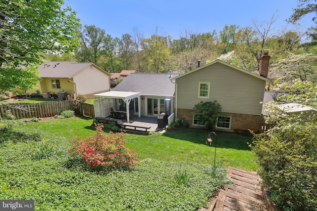 back of house featuring fence, a lawn, a chimney, and a deck